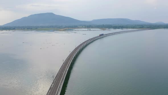 Aerial view of Thai local train on railway bridge at Pa Sak Jolasid Dam, the biggest reservoir