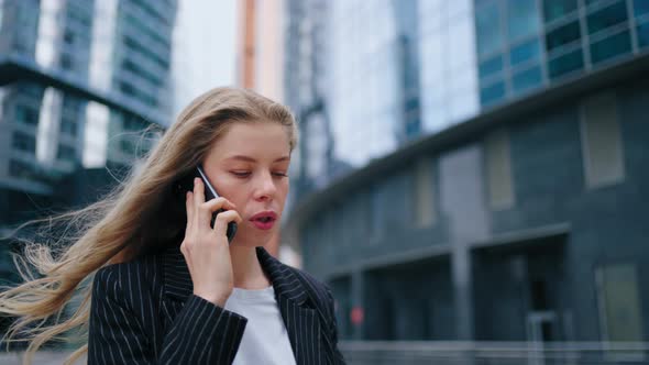 Business Woman Speaking Mobile Phone Onthe Go to Office Outdoors