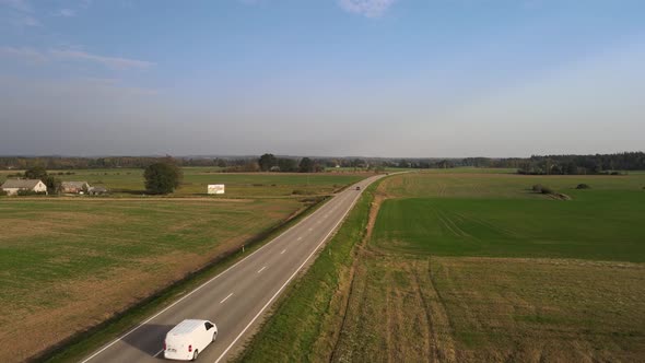 Country side road with cars and fields