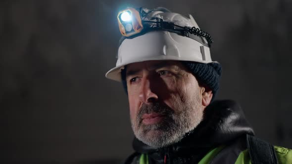 Headshot Portrait Confident Mature Man Looking Around Standing in Frozen Ice Cave with Stalactites