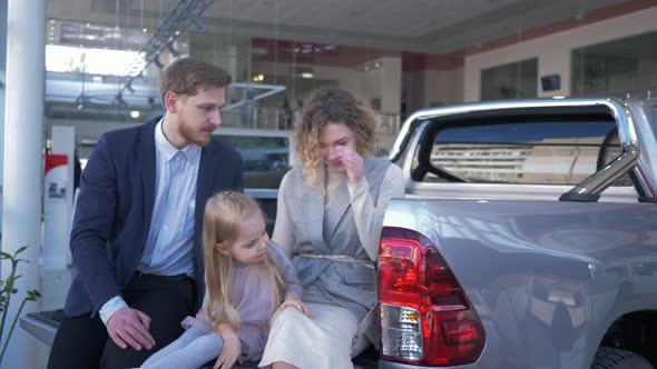 Auto Sale Center, Young Couple with Child Chooses Automobile and Communicate with Each Other While