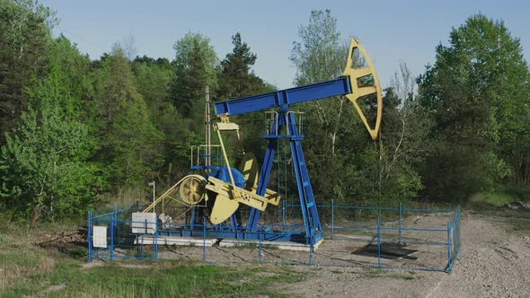 Aerial orbit around oil pumpjack pumping crude oil near Campina, Romania