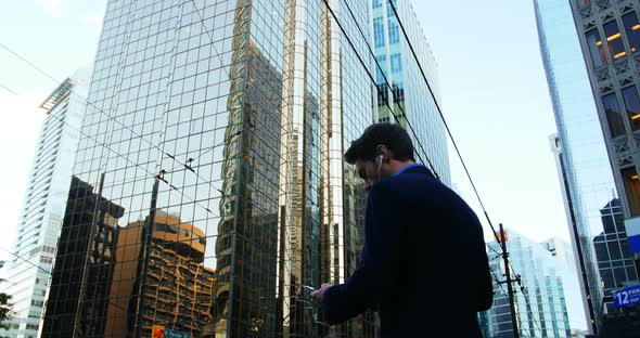 Businessman listening to music and using mobile phone