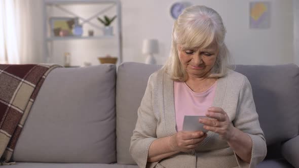 Mature Lady Stroking and Tightly Hugging Photo of Her Family, Missing Children