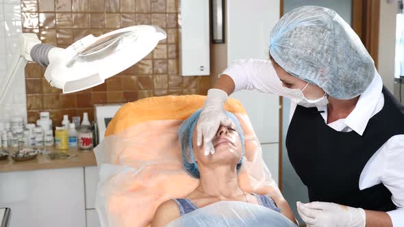 Beautician Applying Anesthesia to a Senior Female Client