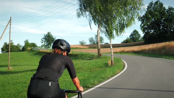 Cycling sport workout. Woman cyclist riding bicycle uphill