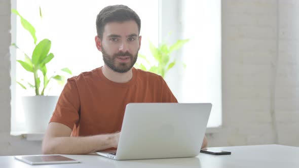 Accepting Young Man Shaking Head at Work