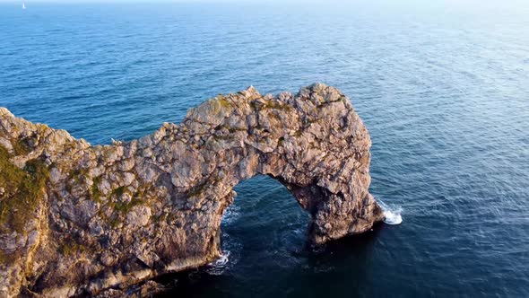 A steady panning shot filmed with a Dji Mavic of the famous, 'Durdle Door' during golden hour along