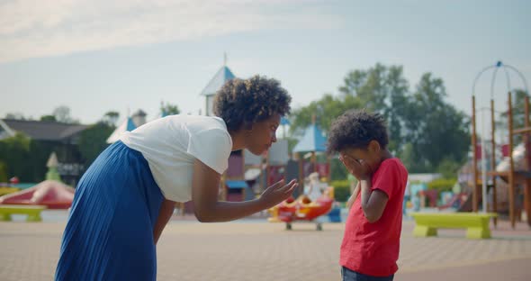 Side View of African Strict Mother Talking to Naughty Son in Park