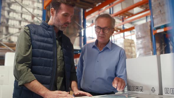 Mature men working togetherness in the warehouse. Shot with RED helium camera in 8K.