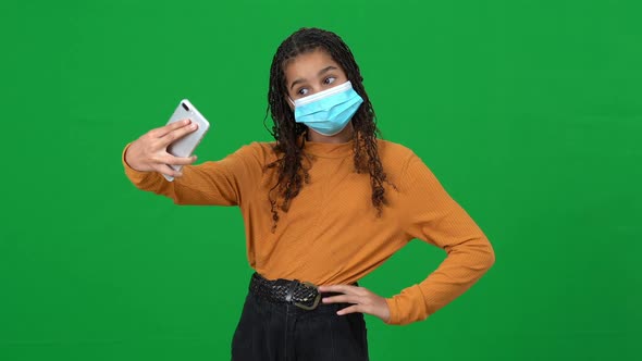 African American Teen Girl in Covid19 Face Mask Taking Selfie Posing at Chromakey Background