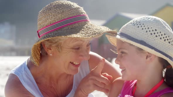 Grandmother and granddaughter playing with each other at beach