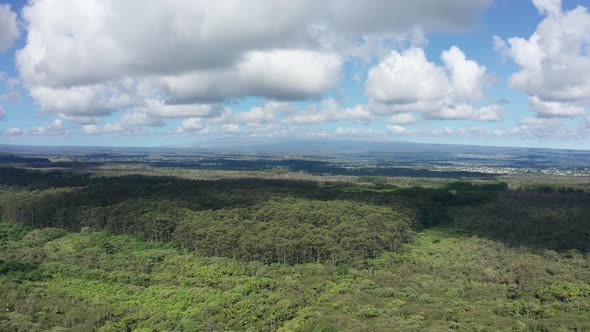 Wide aerial panning shot of both Mauna Loa and Mauna Kea volcanoes with their summits hidden by clou