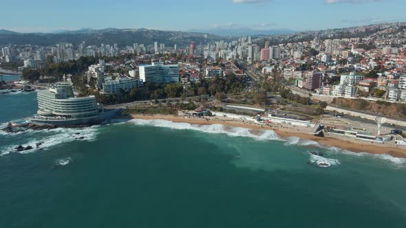 Aerial orbit of luxury resorts near turquoise sea and sand shore, Viña del Mar city buildings and hi