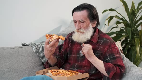 Senior Man Eating Pizza on Couch