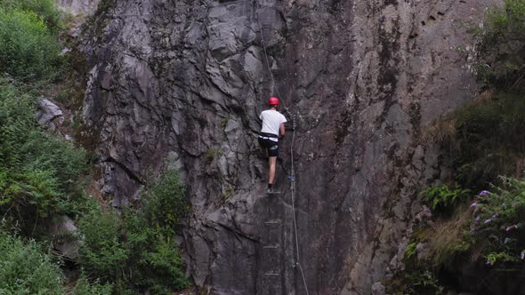 Aerial View Muscular with Red Helmet Rockclimber Climb on Tough Sport Route in