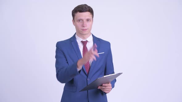 Young Handsome Businessman Talking While Holding Clipboard