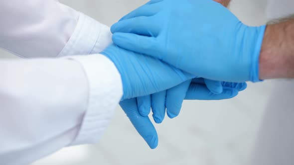 Closeup Handstack of Caucasian Doctors Hands in Disposable Blue Gloves