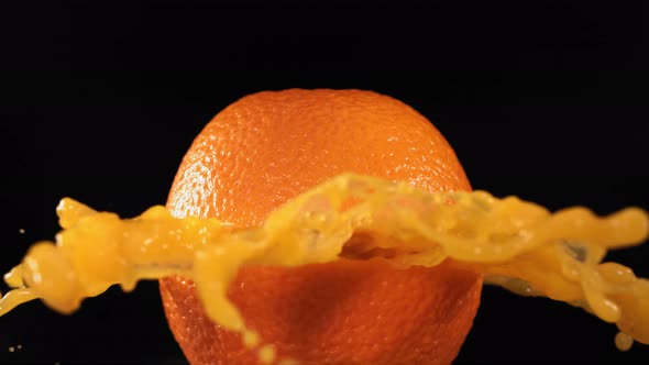 Fresh Orange Fruit Squirting and Burst with Juice in Slow Motion in Black Background