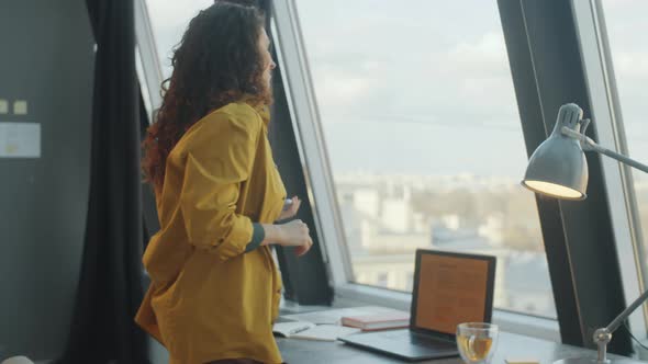 Woman Using Phone, Drinking Tea and Working on Laptop in Office