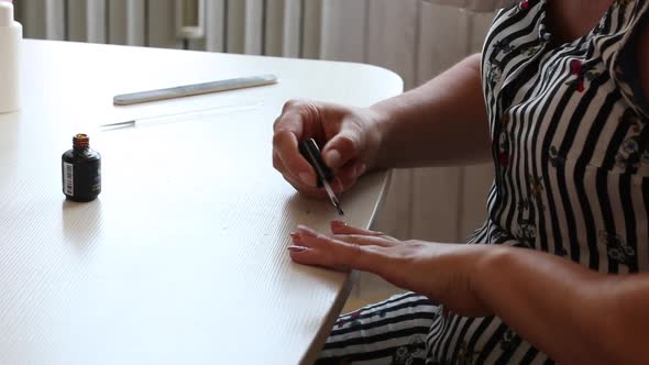 A Woman Applies Nail Polish. Does A Manicure