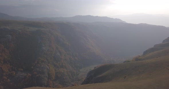 Aerial view mountain landscape autumn, orange trees, rocks on hillside, Durmitor park, Montenegro