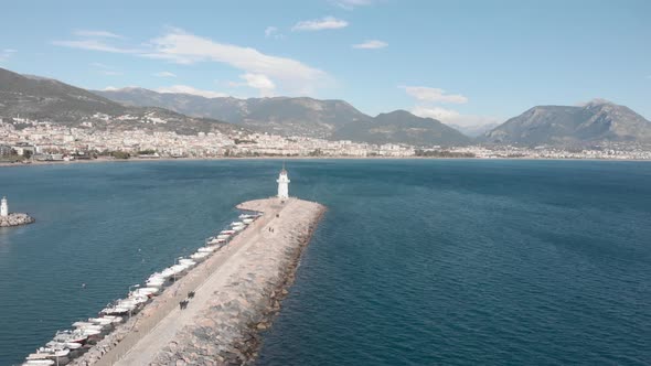 Harbor with lighthouse in calm blue sea, Alanya, Turkey.