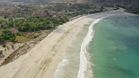 Waves By the Shore and Boats Anchored with Trees in the Surrounding Area