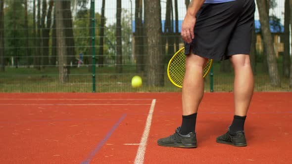 Tennis Player Serving a Ball To Start a Point