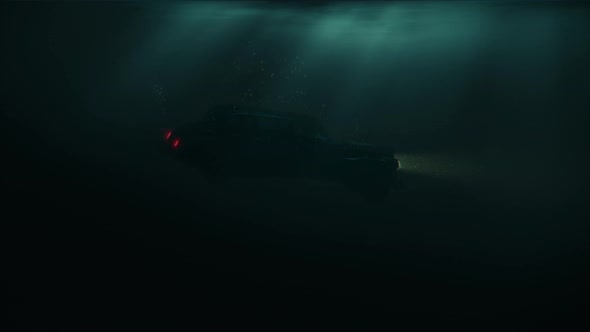 Sinking Car with Headlamps and Bubbles in Dark Water Under Sun Rays