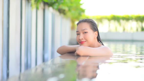 Young asian woman enjoy around outdoor swimming pool for leisure