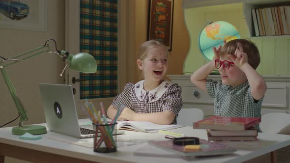 Two Happy Kids Showing Goat with Horns to Online Teacher and Laughing Together