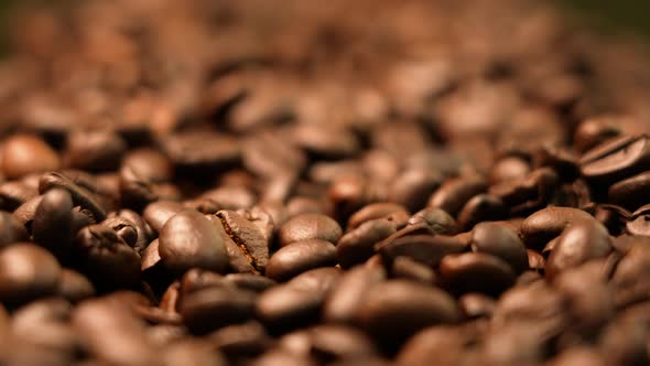 Roasted coffee beans falling down in golden light