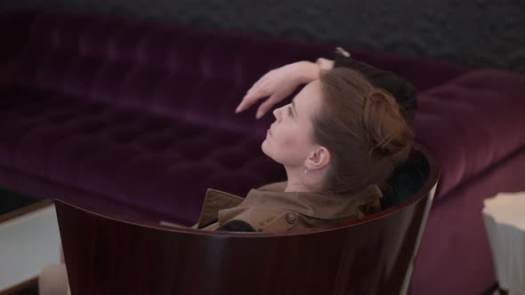 Side View Happy Woman Leaning on Wooden Armchair Backrest Smiling