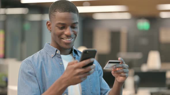 Young African American Man Making Online Payment on Smartphone