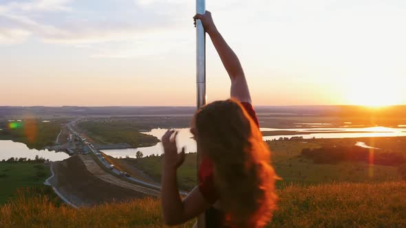 Pole Dance on Sunset - Young Woman in Sports Clothes Spinning By the Pole with Spread Legs