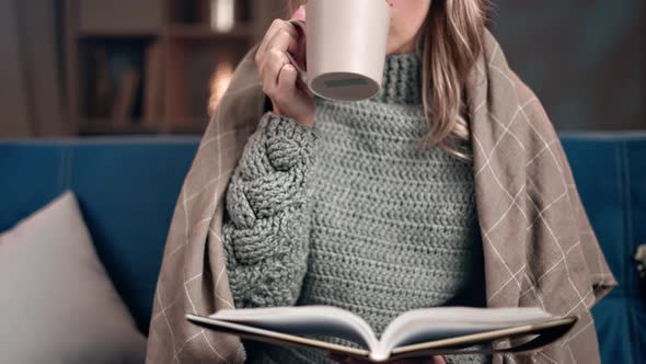 Unrecognizable Relaxed Female Covered Warm Plaid Drinking Hot Beverage Reading Book Winter Evening