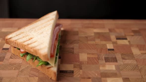 Woman Preparing Sandwich with Ham and Cheese Slice in the Kitchen Closeup