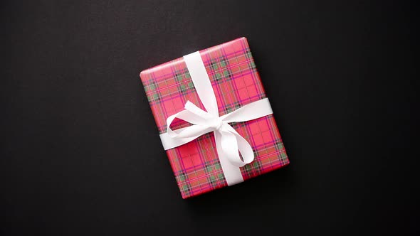 Red Gift Box with White Bow on Black Table, Top View