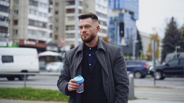 Young man drinking coffee in the street. 