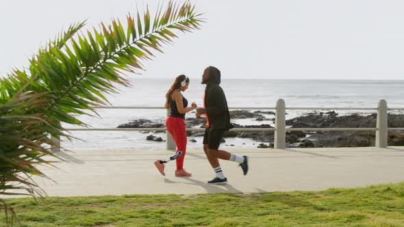 Couple jogging at promenade on a sunny day 4k