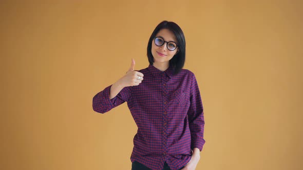 Portrait of Happy Girl with Black Hair Showing Thumbs-up Smiling Recommending