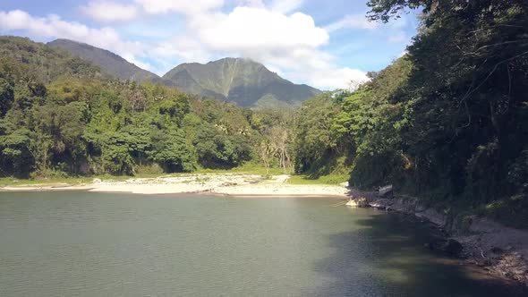 Flying Over the Lake and Rainforest with Mountains in Sunny Summer Day.