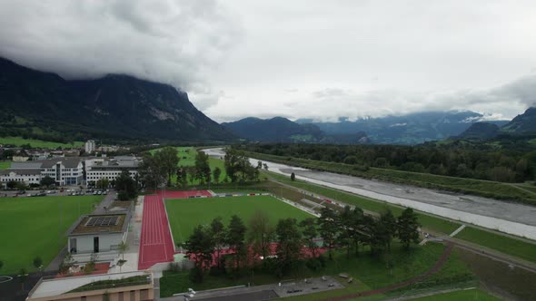 Liechtenstein with Houses on Green Fields in Alps Mountain Valley Aerial View