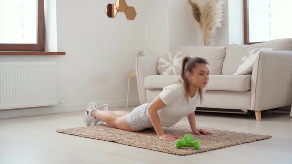 Young Woman Does Push Ups on the Floor at Home Home Fitness