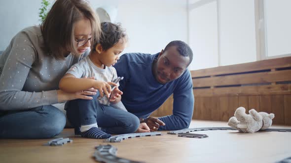 Happy Multiracial Family at Home Playing with Baby