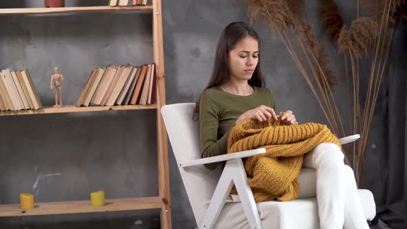 Crochet at Home Young Latin Woman Knitting a Warm Sweater of Woolen Yarn Girl Sitting in a Cozy