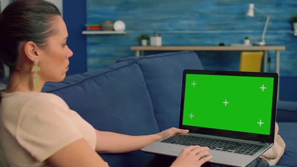 Freelancer Using Laptop Computer with Mock Up Green Screen