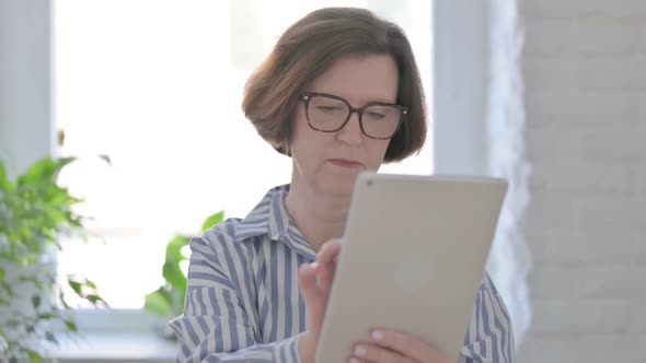 Portrait of Senior Woman Using Tablet in Office