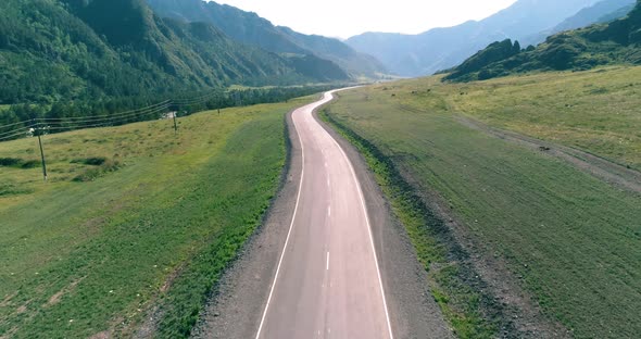 Flight Over Mountain Asphalt Highway Road and Meadow